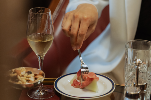 An up-close shot of a diner tucking into a gourmet dish on a polished table.